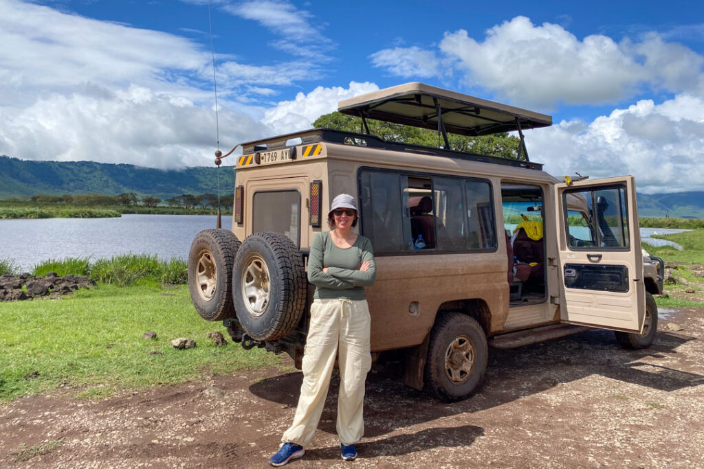 Ich stehe vor dem Safari Jeep im Ngorongoro Krater in Tansania