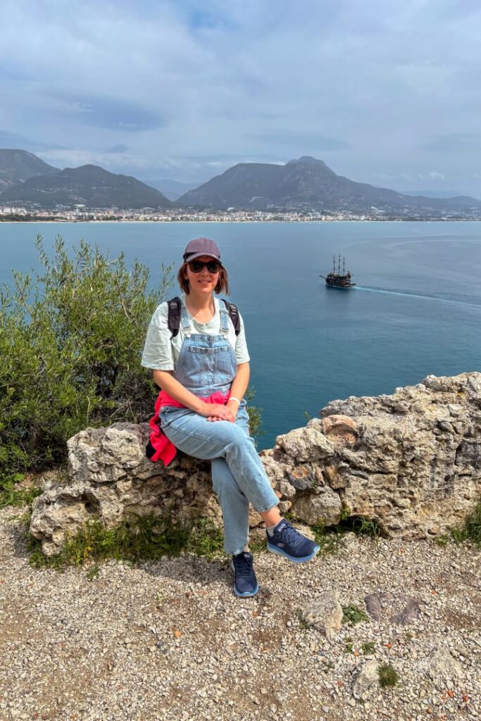 Eine Frau, die auf einem Felsen am Wasser sitzt