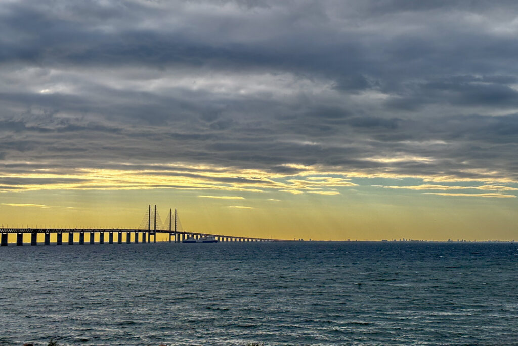 Eine lange Brücke über dem Meer mit Sonnenuntergang
