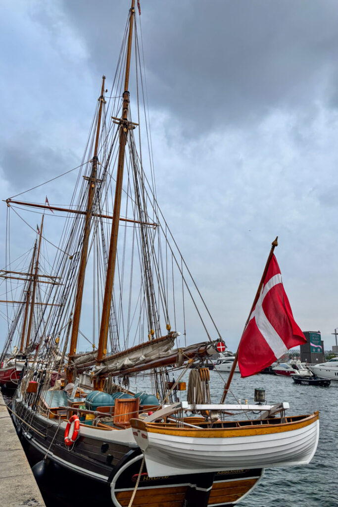 Ein Schiff mit einer rot-weißen Flaggen liegt in einem Hafen
