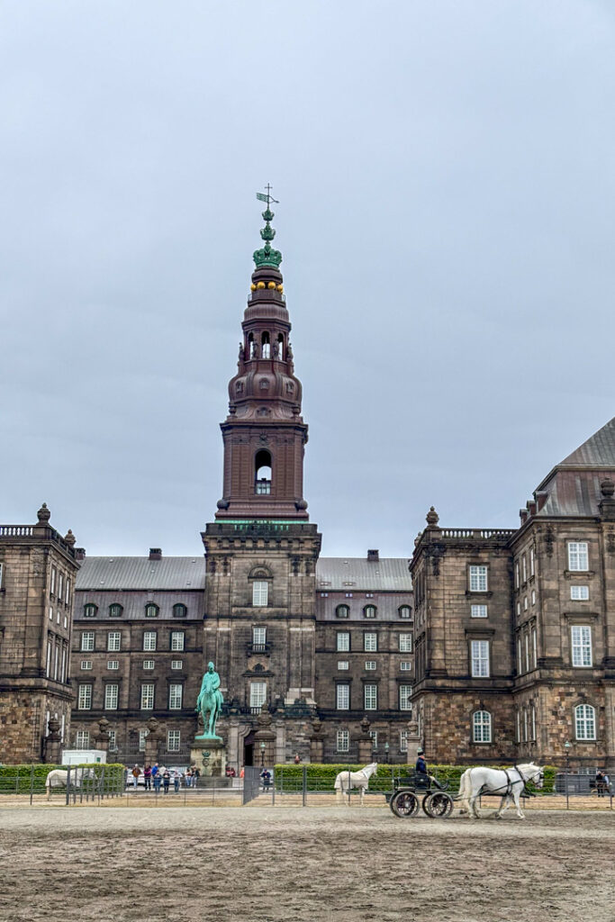 Ein braunes Gebäude mit einem Turm und einem Pferd davor