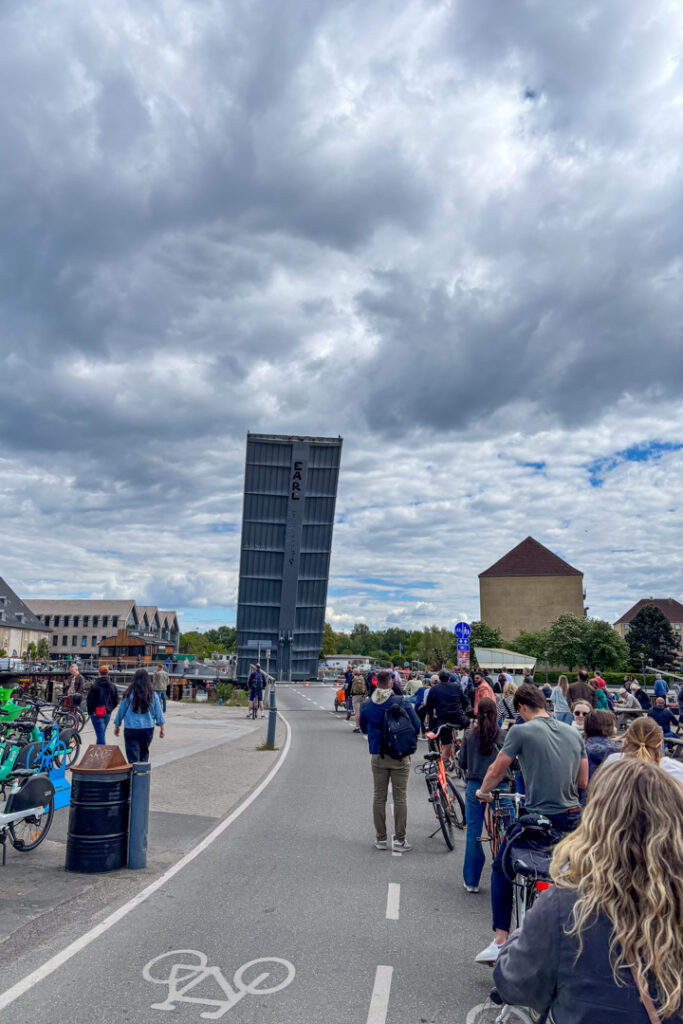 Viele Menschen auf einem Fahrrad, die vor einer Brücke warten