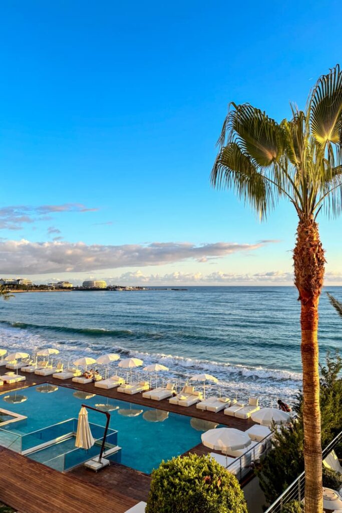 Blick vom Balkon auf einen Pool und das blaue Meer
