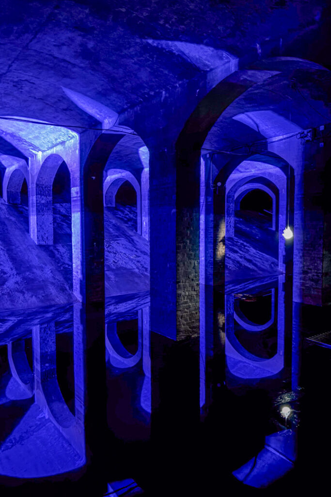 Ein blau beleuchteter Raum mit Säulen und Bögen