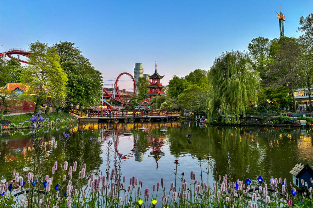 Eine Pagode und Achterbahn inmitten viel Grün und Wasser