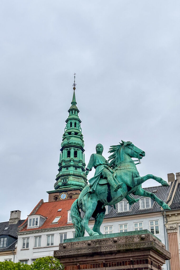Eine Statue mit einem Reiter und eine Kirche im Hintergrund