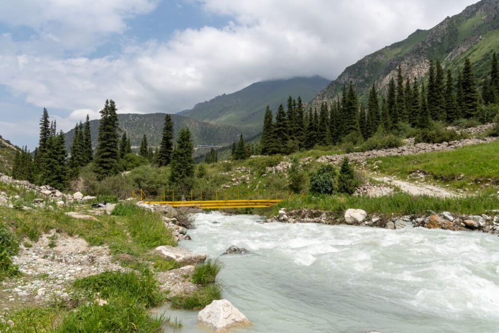 Ein Fluss, eine gelbe Brücke in einer grünen Landschaft 