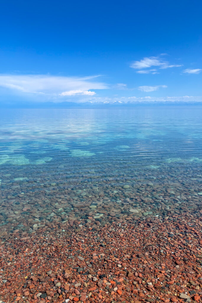 Klares blaues Wasser mit braunen Steinen 