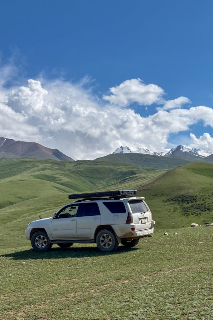Ein weißes Auto in einer grünen Berglandschaft