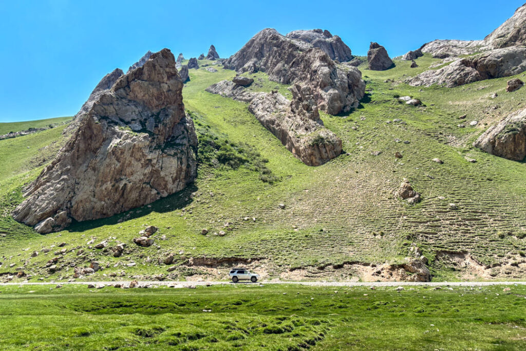 Ein weißes Auto auf einer Piste inmitten einer Berglandschaft