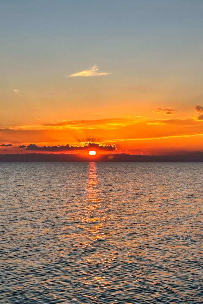 Sonne geht unter am Horizont über einem See