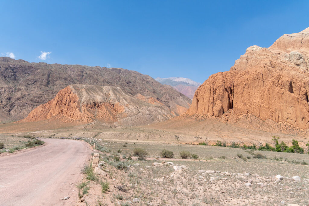 Eine wüstenähnliche Landschaft mit einer Schotterpiste