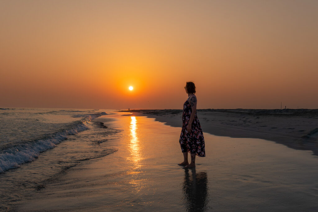 Eine Frau am Strand bei einem Sonnenuntergang