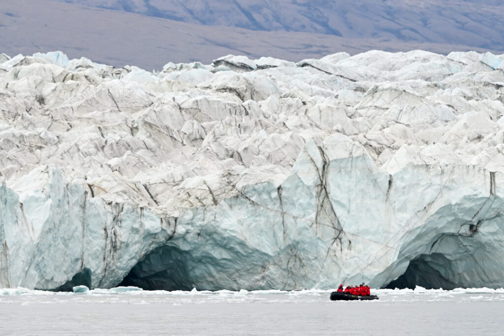 Ein Schlauchboot vor einem riesigen Gletscher