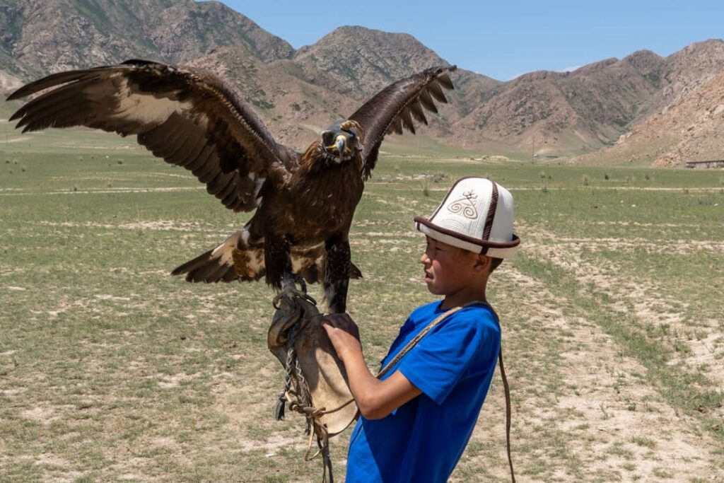 Ein Junge mit einem blauen T-Shirt und einem Adler auf dem Arm