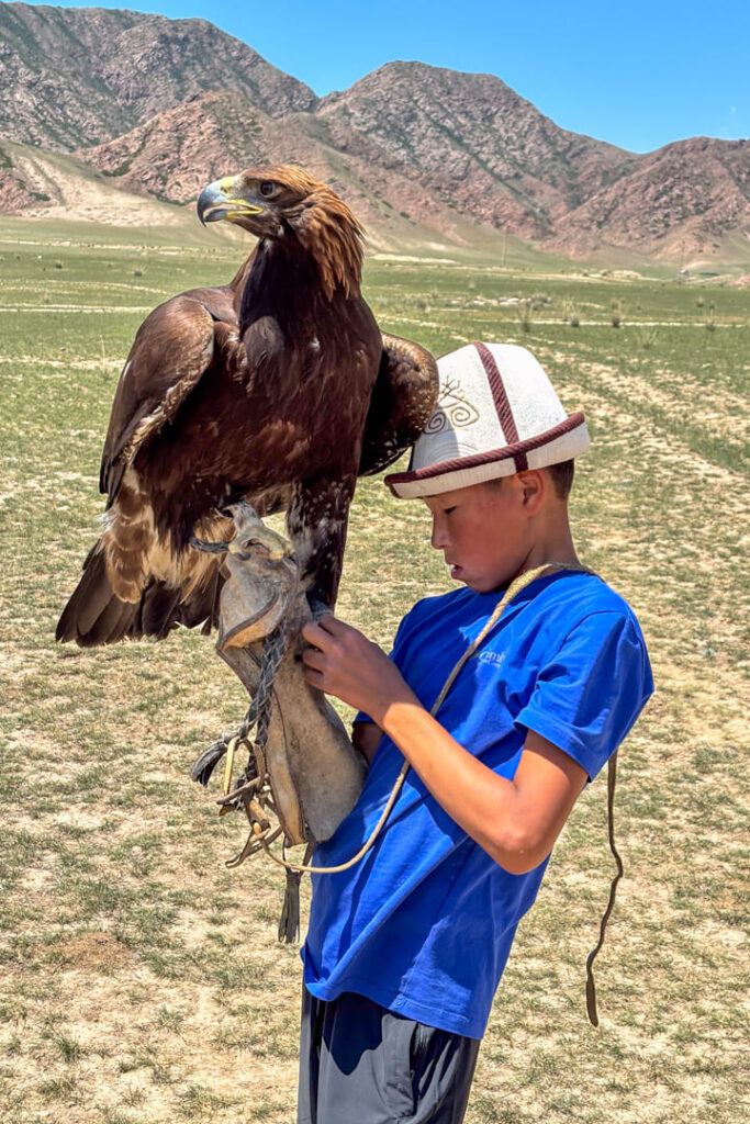 Ein Junge mit einem Steinadler auf der Hand
