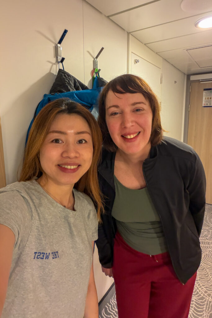 2 Frauen in einer Kabine, die zusammen in die Kamera schauen