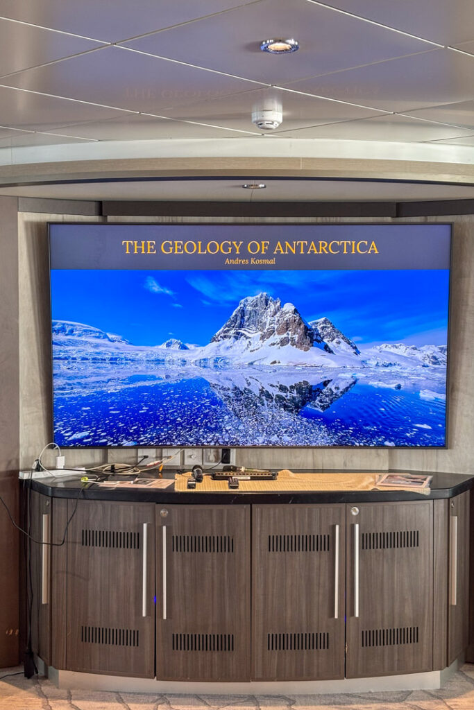 Ein großer Bildschirm, der "The Geology of Antarctica" anzeigt