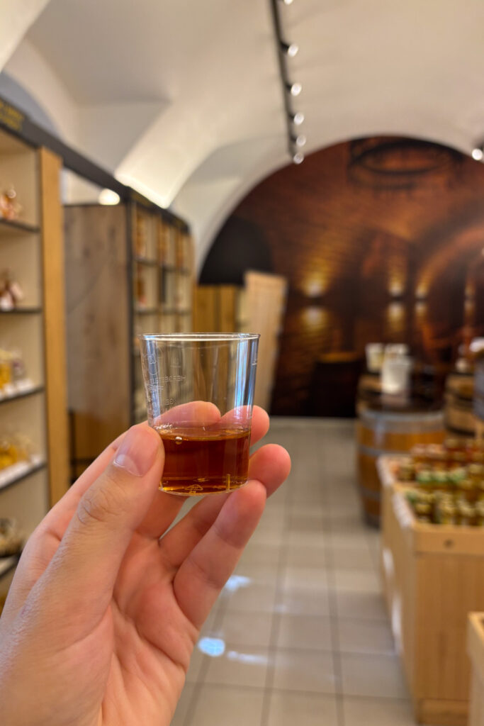 Eine Hand hält einen Shot Honigwein in die Höhe