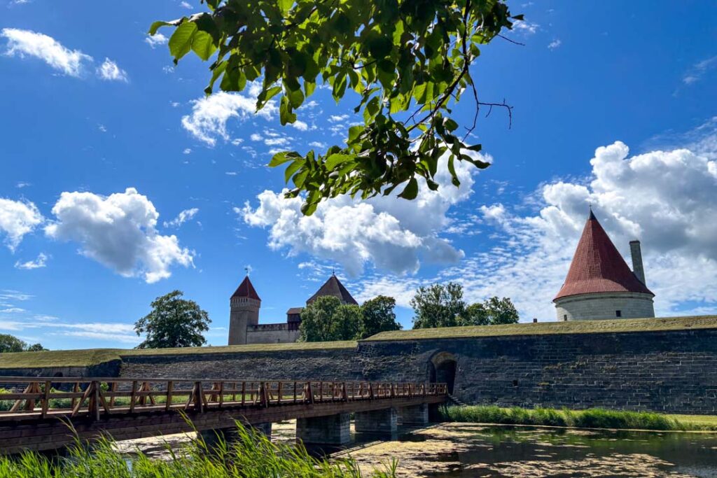 Mehrere Türme hinter einer alten Mauer und Graben