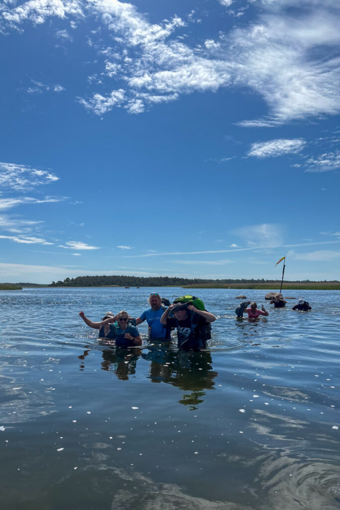 Eine Gruppe läuft durch brusthohes Wasser im Vilsandi-Nationalpark