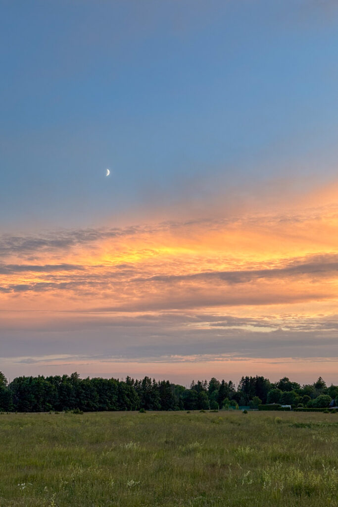 Sonnenuntergang und farbiger Himmel auf einer weiten grünen Landschaft